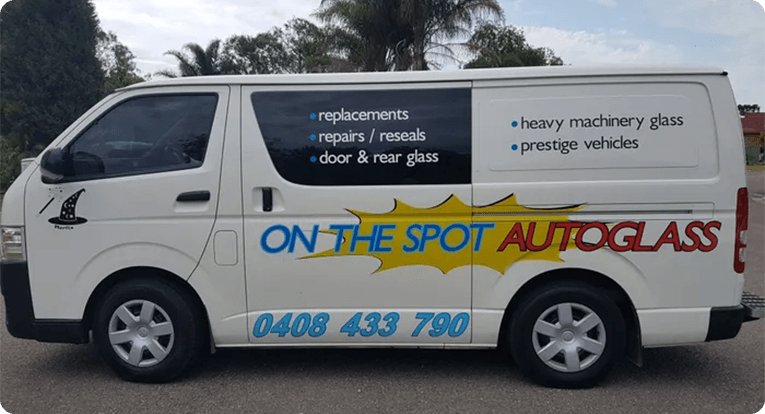 A white van with the words " on the spot auto repair " written in blue lettering.